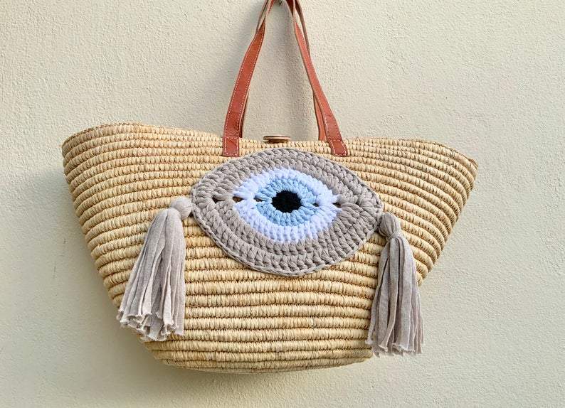 Straw tote basket with crochet evil eye